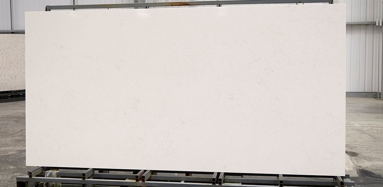 Full Slab view of Carrara Quartz with a soft white hue and smoky grey veins.