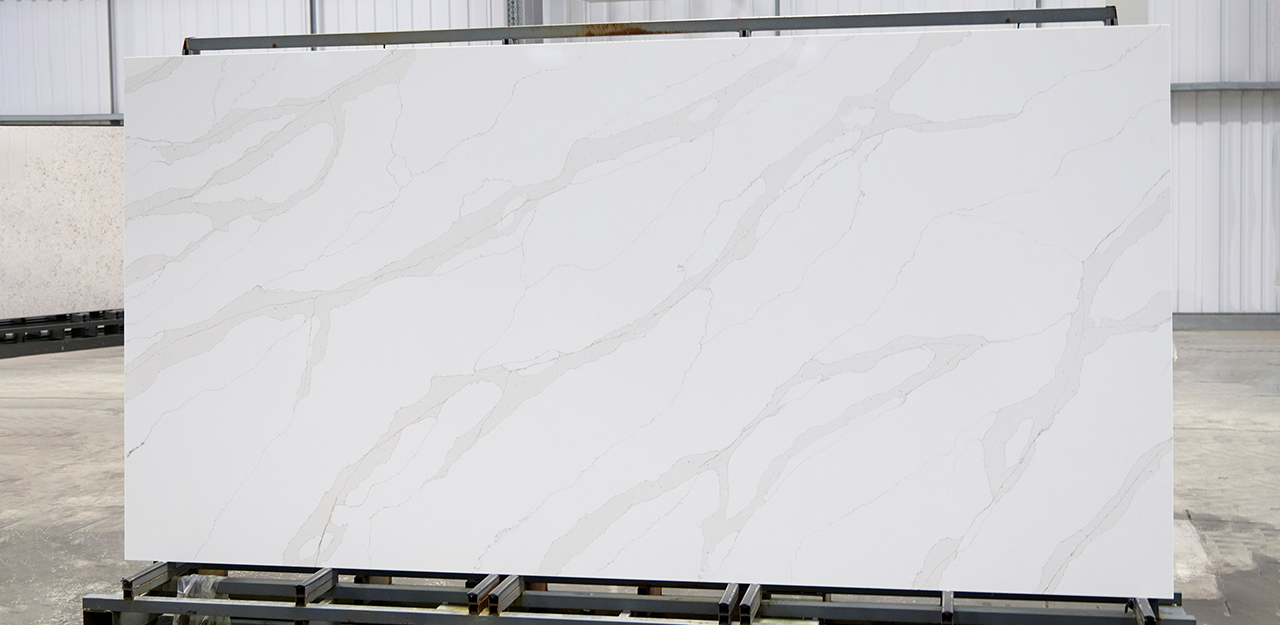 Full Slab view of Calacatta Dorado Quartz with a white surface and a dramatic veining.