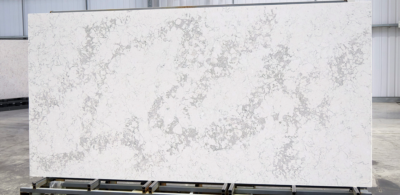 Full Slab view of Statuario Verde Quartz with a white base interjected with dark patterning