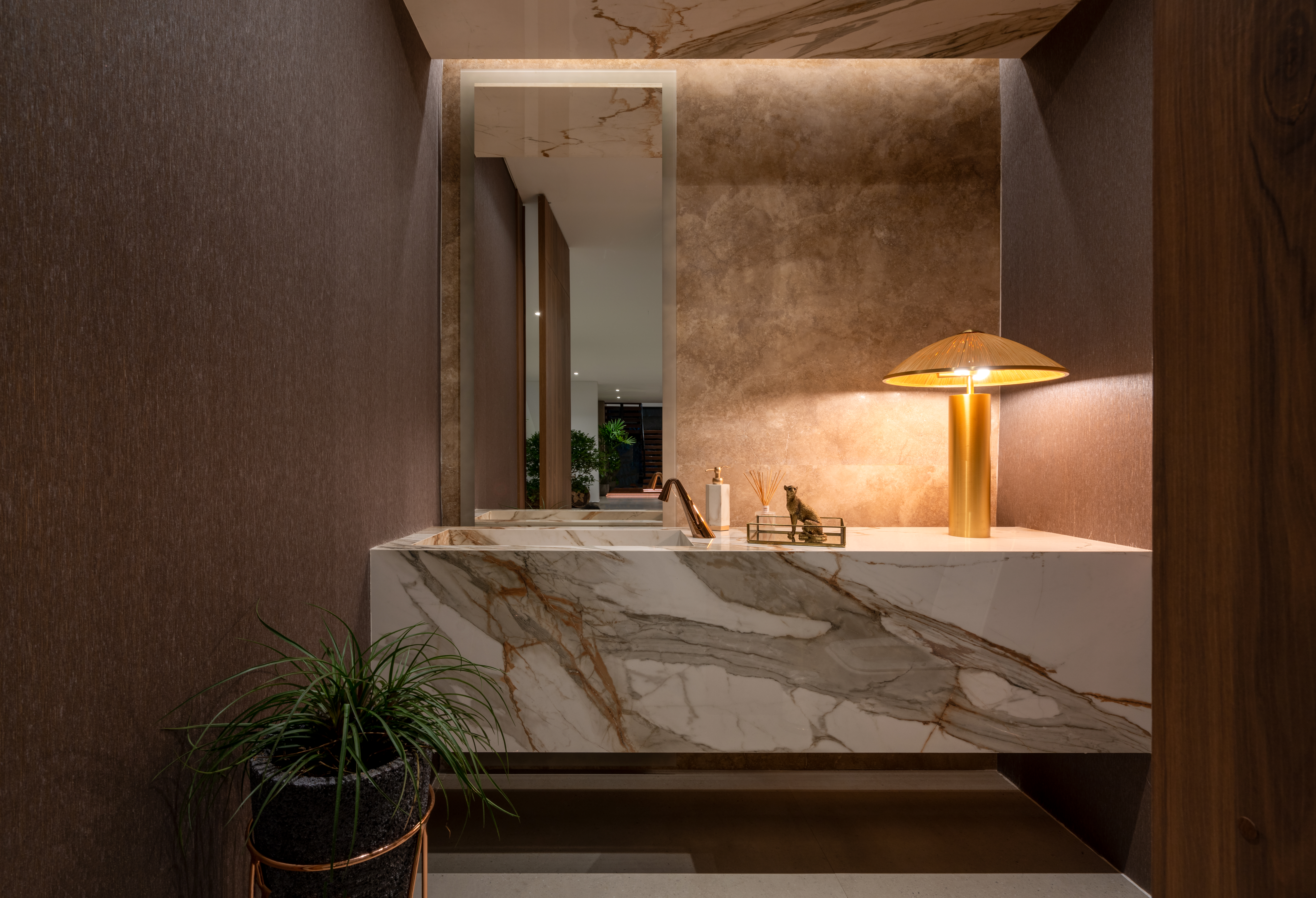 A well-designed and trendy bathroom vanity featuring a surface with bold gold and bronze veining on a white background.